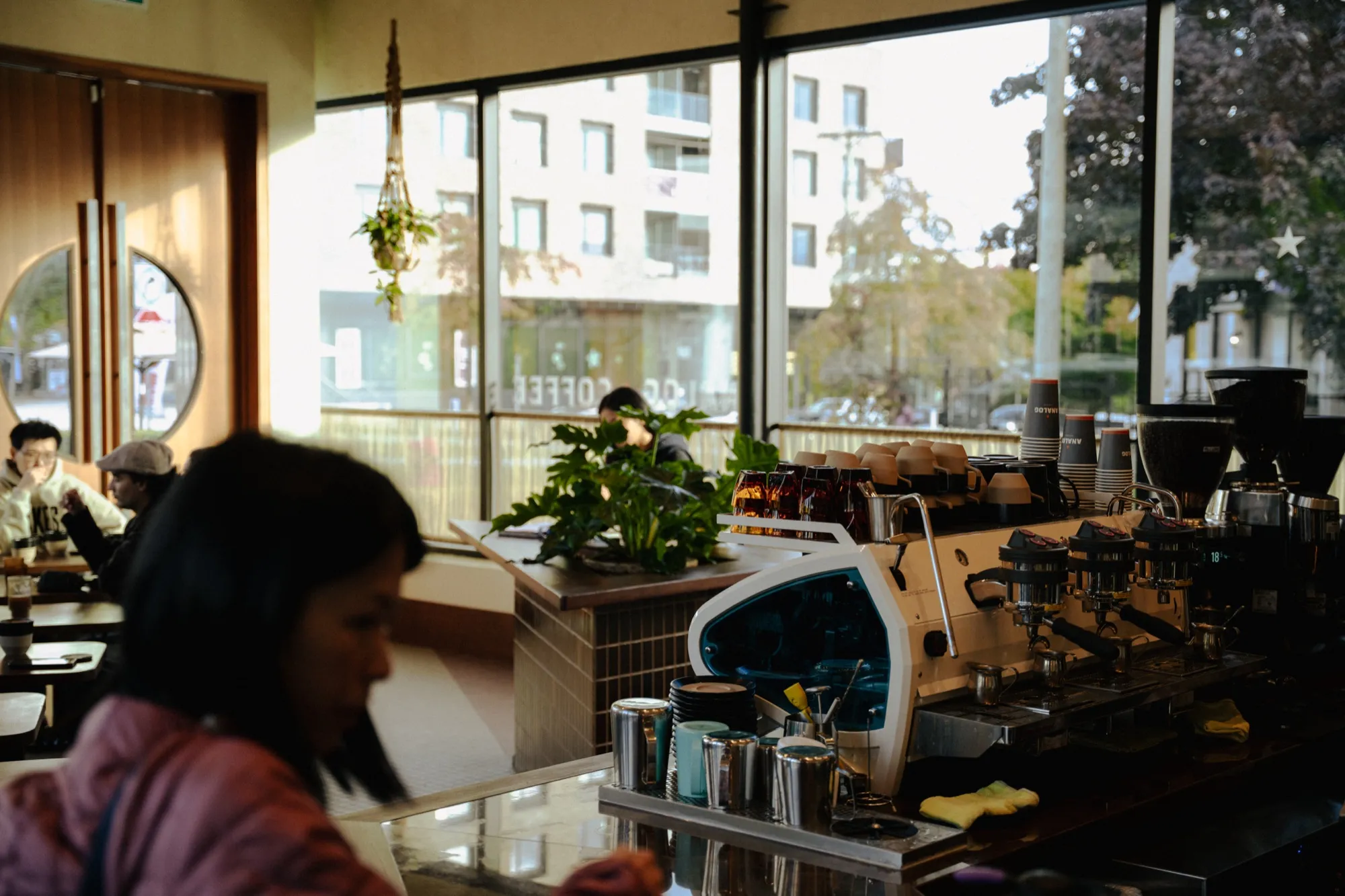 Cozy cafe espresso bar with customer and street view through large windows